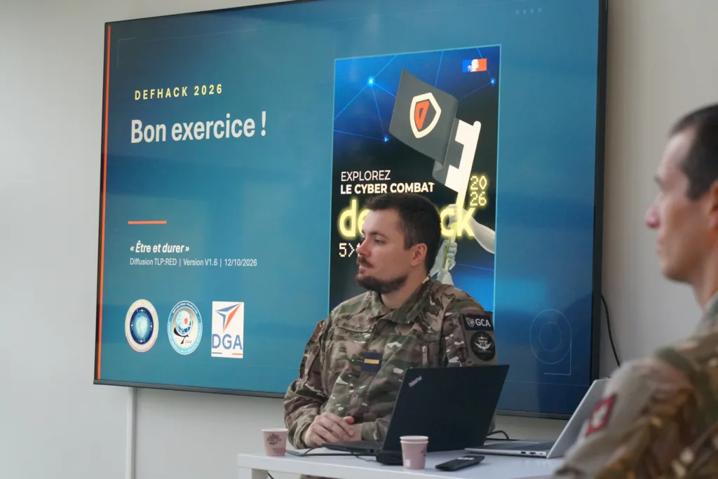 Présentation du scénario du DefHack 2026 par le COMCYBER à Epitech Rennes Deux représentants du COMCYBER en tenue militaire présentent le DefHack 2026 aux étudiants d’Epitech Rennes
