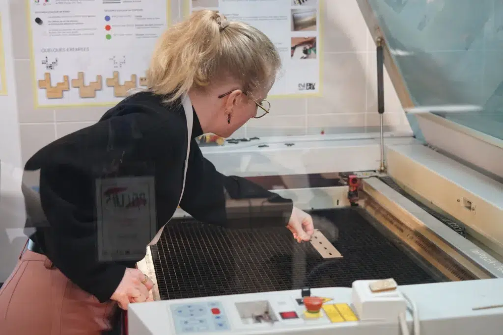 Facilitatrice du hackathon à Rennes POCL #5 utilisant une découpeuse laser à l’Edulab